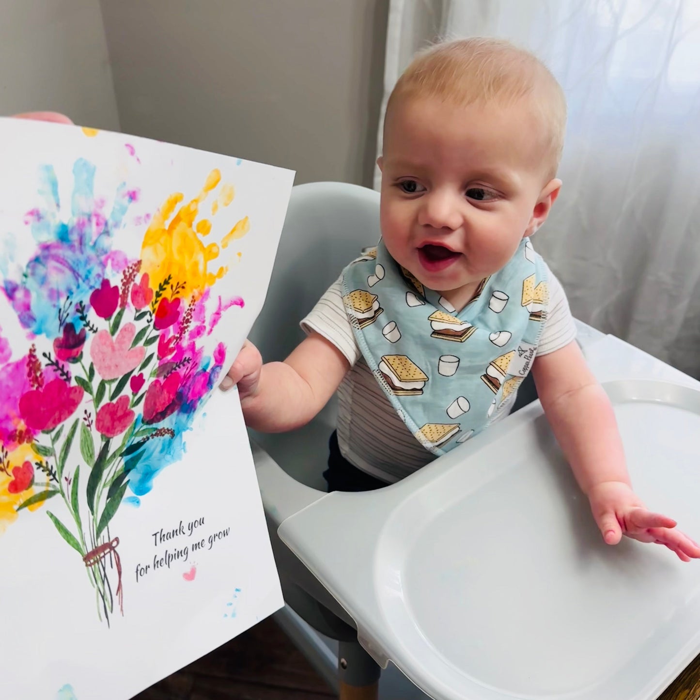 Baby in a high chair holding a colorful bouquet handprint art gift