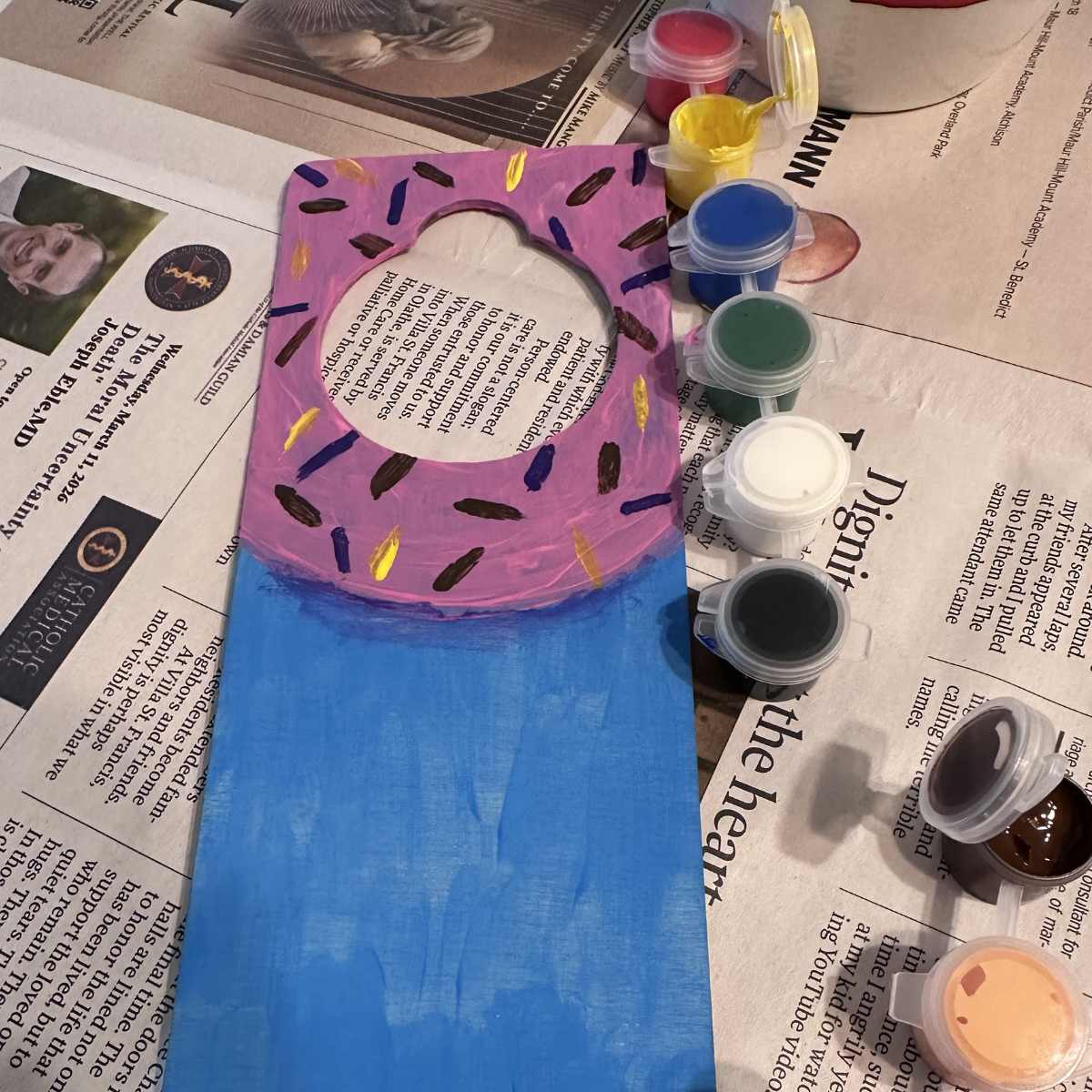 Decorative picture frame with pink donut design on a newspaper background