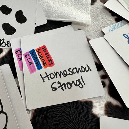 Close-up of custom Memory Mix cards with hand-drawn school subjects and ‘Homeschool Strong!’ message on a white matte card surface.