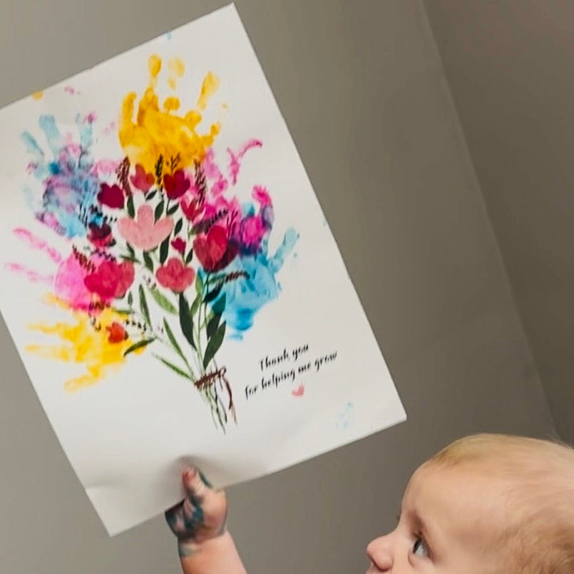 Child holding a colorful easy fingerprint handprint gift made with paint for flower picture for mom or grandma