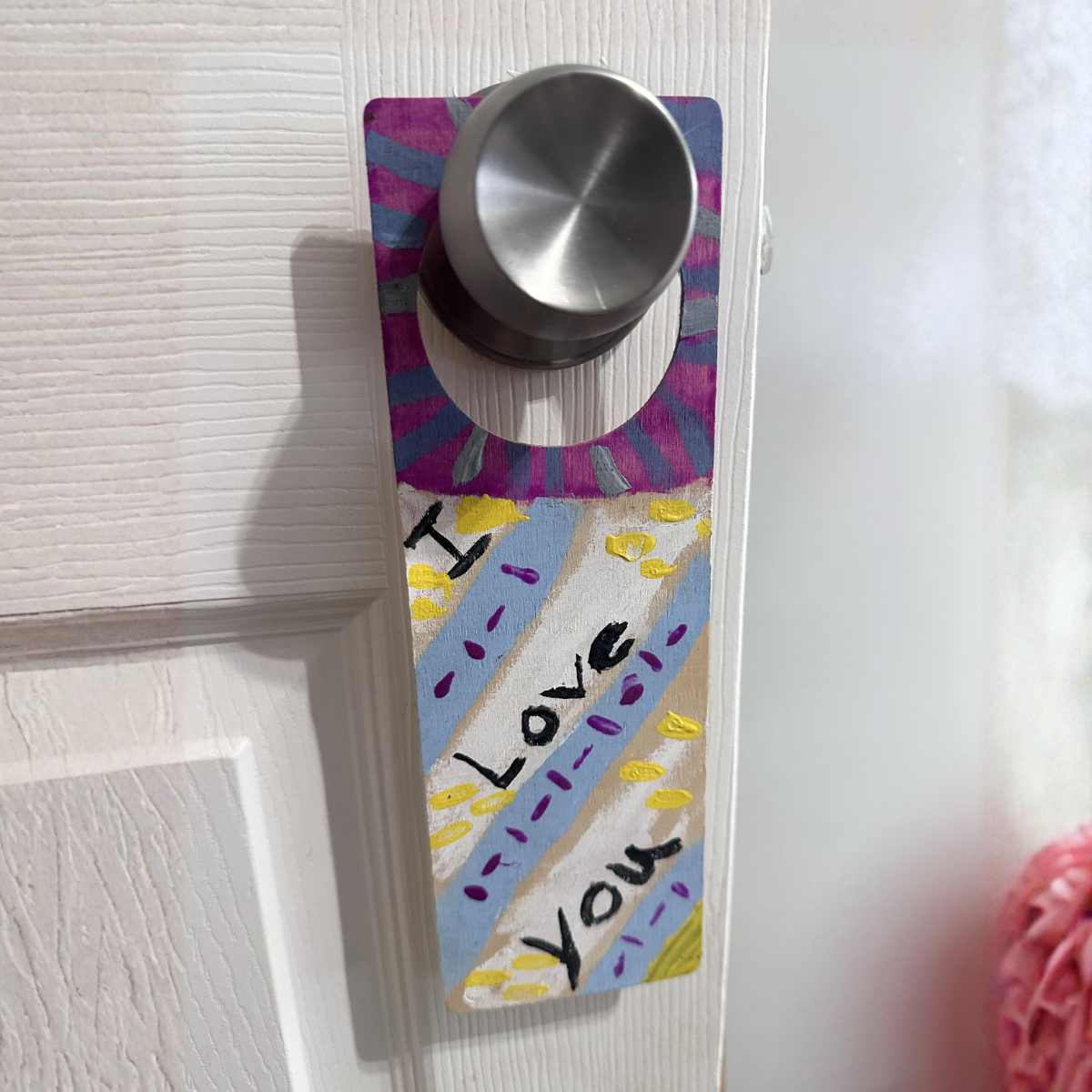 Hand-painted personalized door hanger on a door, homemade gift made with family